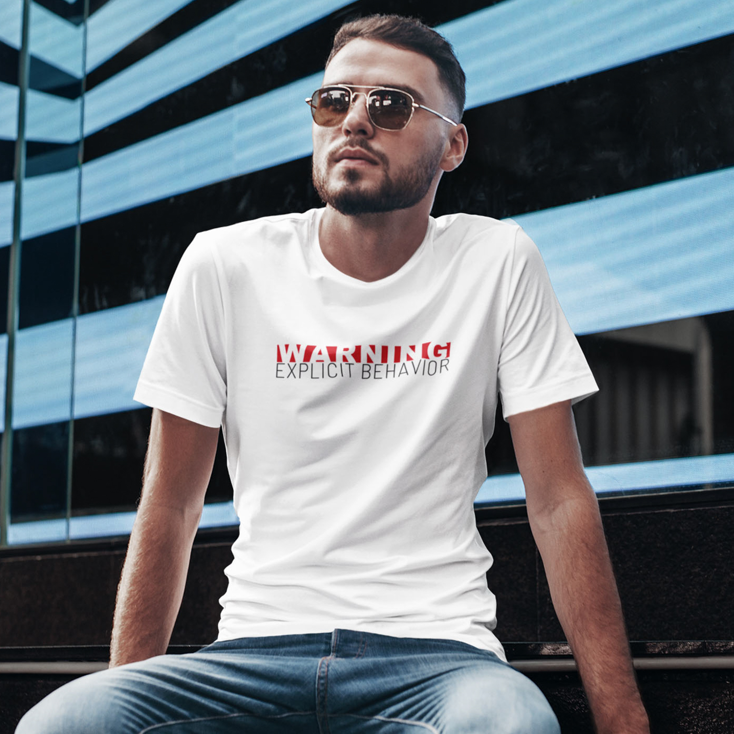Junger Mann mit weißem T-Shirt mit "Explicit Behavior" Aufdruck